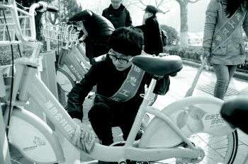 3日,在潍坊市东风街,志愿者正在擦拭公共自行车和停车桩。随着雷锋日的临近,潍坊职业学院信息工程学院的志愿者到潍坊街头,清洁公共自行车和停车桩。